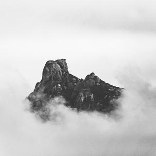 Vue du ciel, une mystérieuse formation rocheuse perce les nuages.